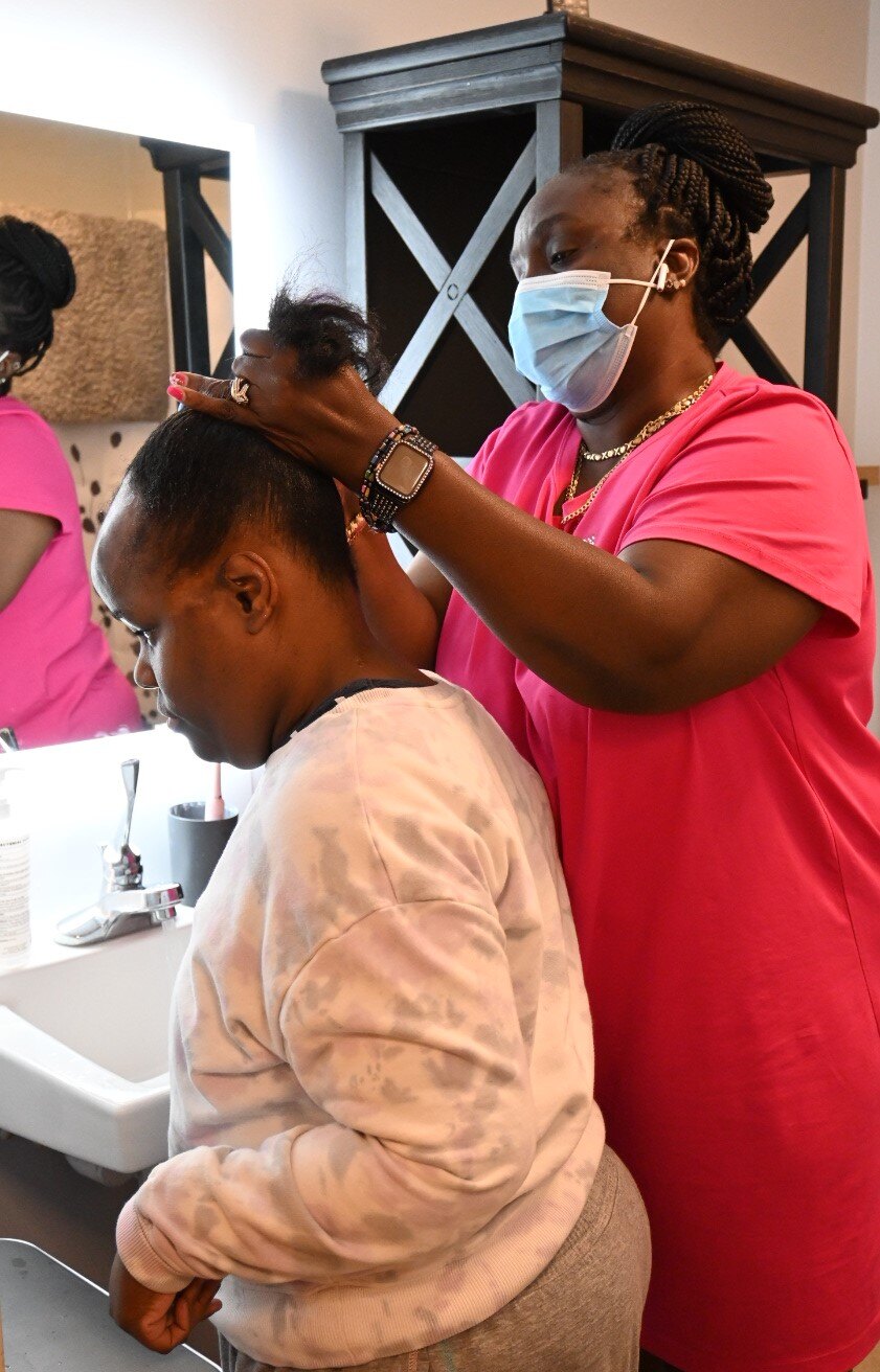 A Pathlight Direct Service Provider helps an individual with her hair.